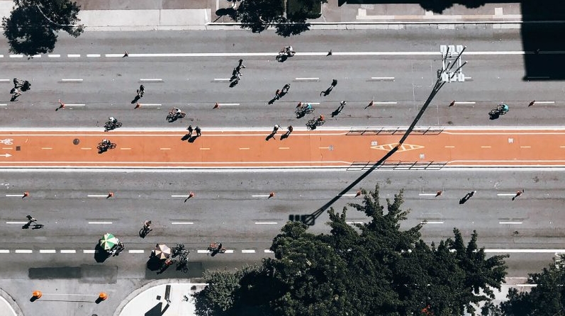 Sky view of passers-by in a street under a heavy sun